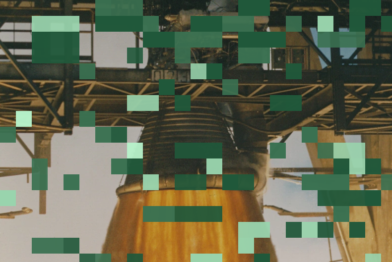 An F-1 rocket engine on the test stand, overlaid with green pixel blocks